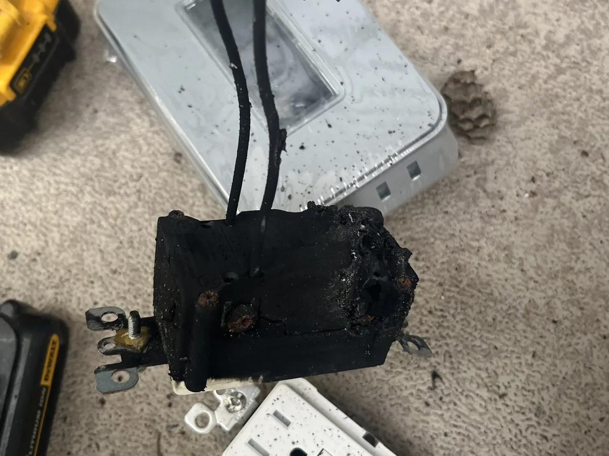 A burnt outlet and scorched wires taken out of a wall
