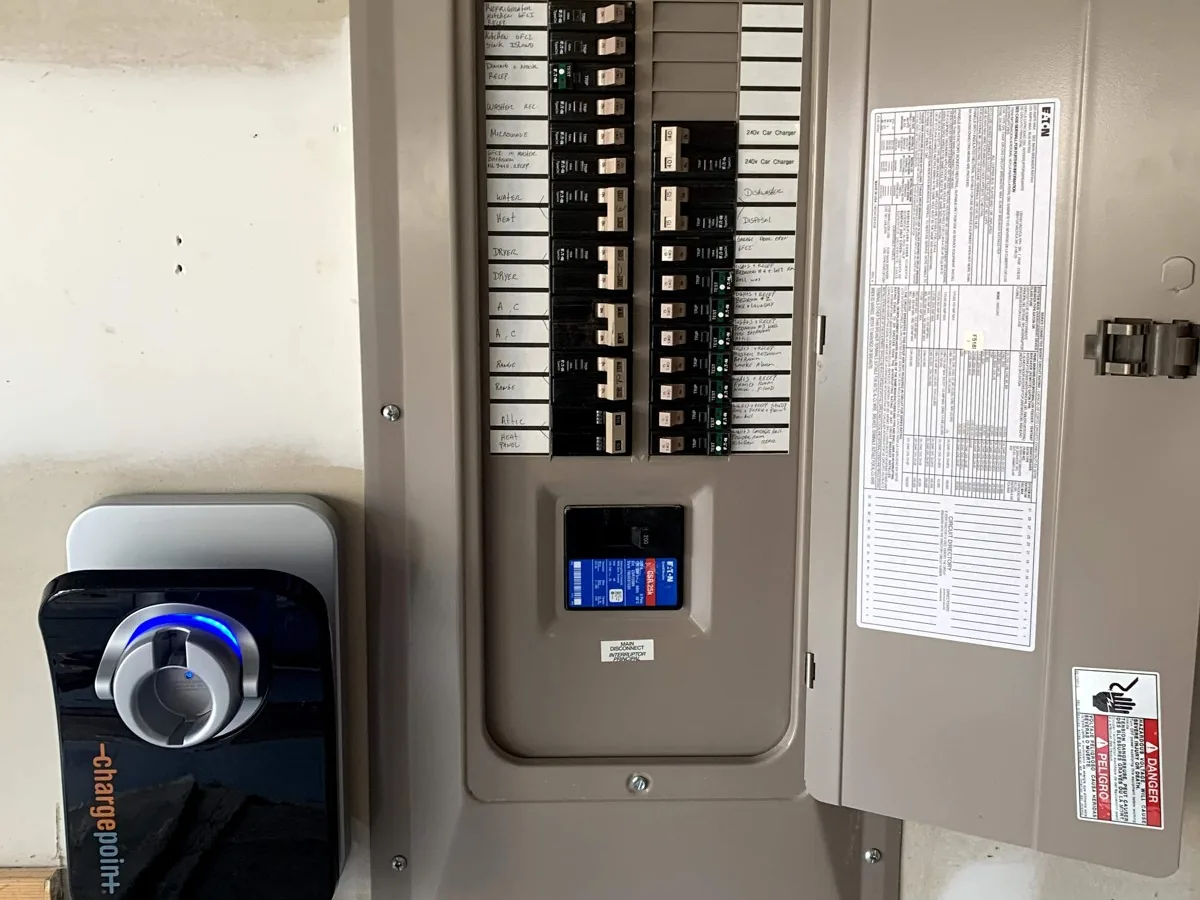 ChargePoint Level 2 EV charger mounted beside an electrical panel with a 240V car charger breaker
