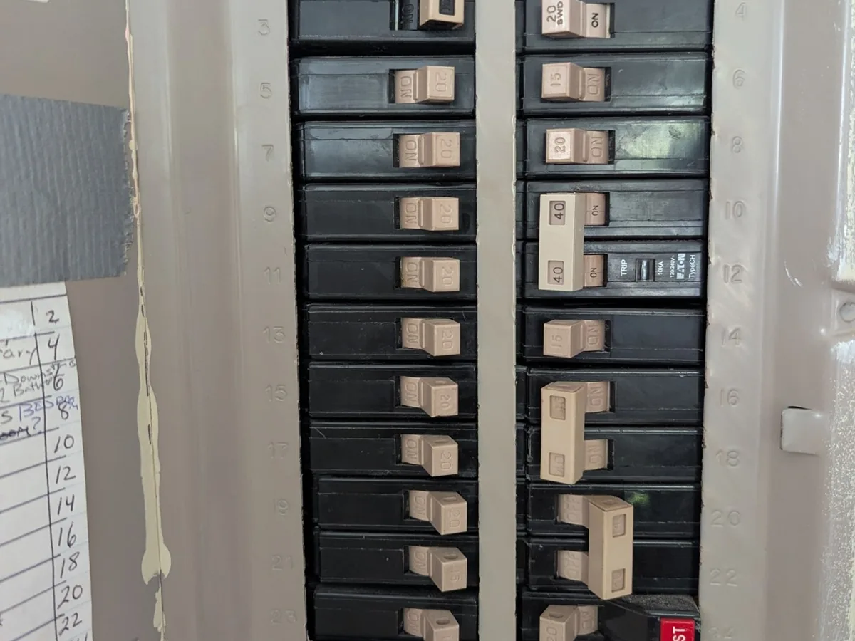 Two rows of breakers in a panel, with the numbered circuit directory beside them