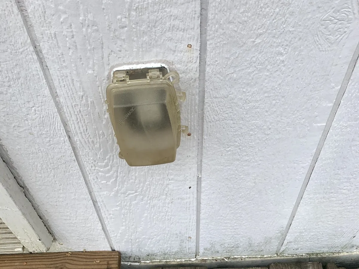 Outdoor outlet with a weatherproof in-use cover on house siding