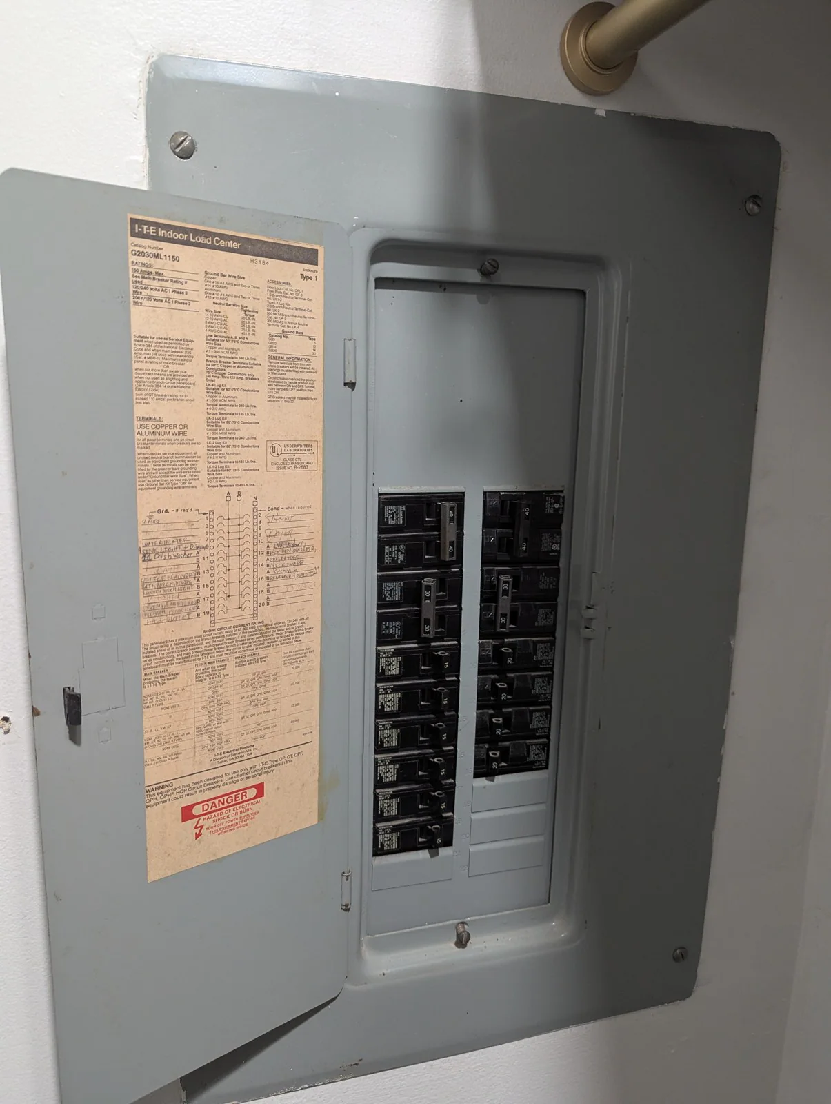 Open electrical panel mounted on an interior wall, with rows of breakers and a label inside the door, in Hayes Barton, Raleigh