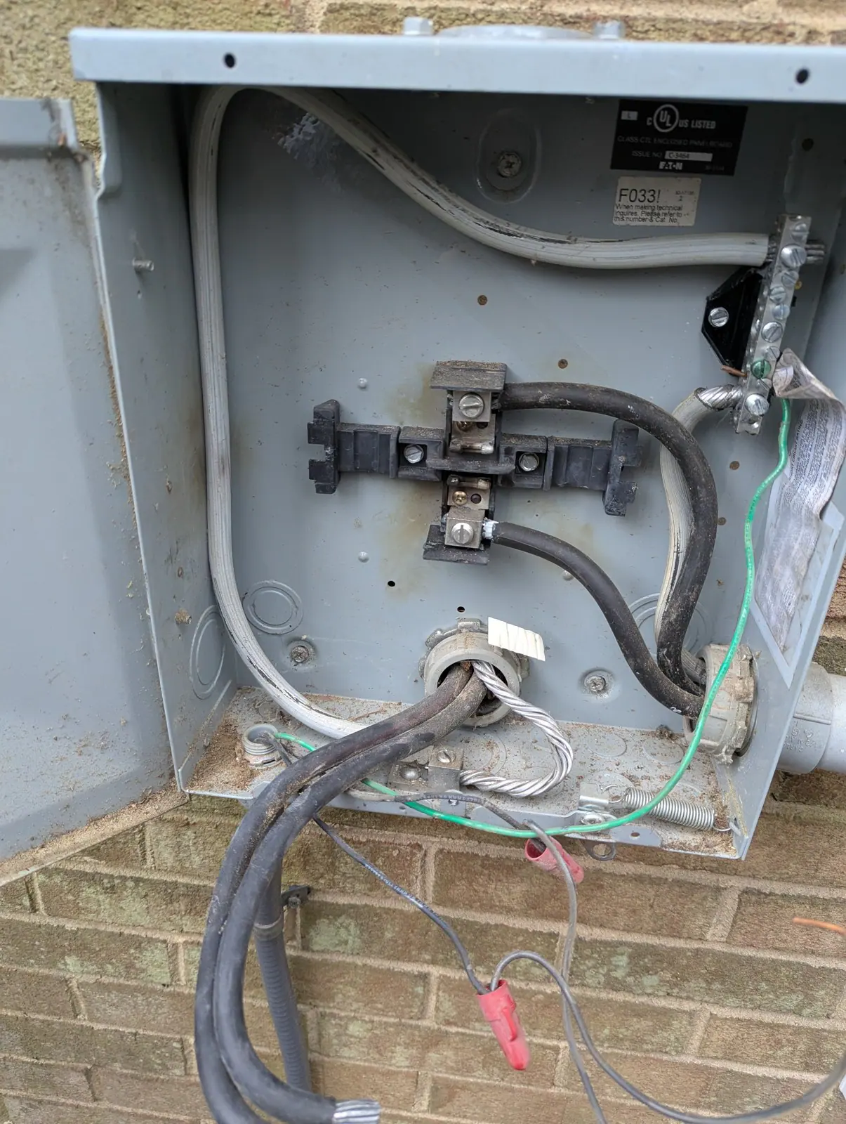 Open electrical enclosure with wires and connectors exposed, mounted on an exterior brick wall, in Hayes Barton, Raleigh