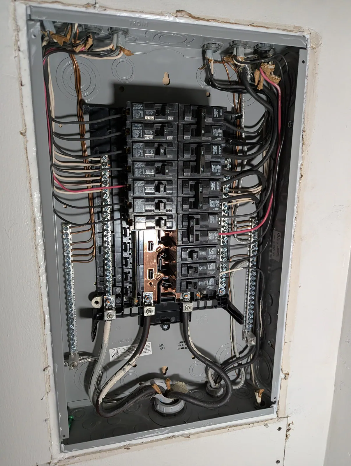 Exposed electrical panel with tangled wires and worn connections, in Hayes Barton, Raleigh
