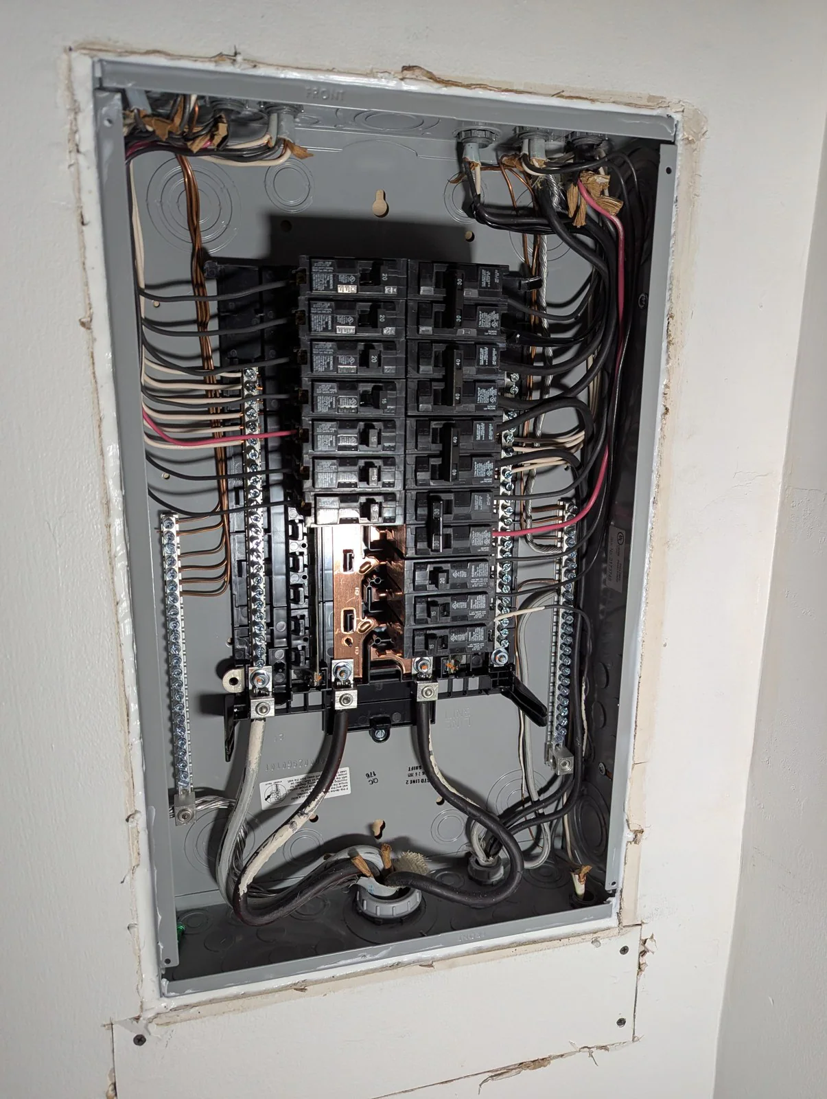 Exposed electrical panel with damaged-looking wires and loose connections, in Hayes Barton, Raleigh