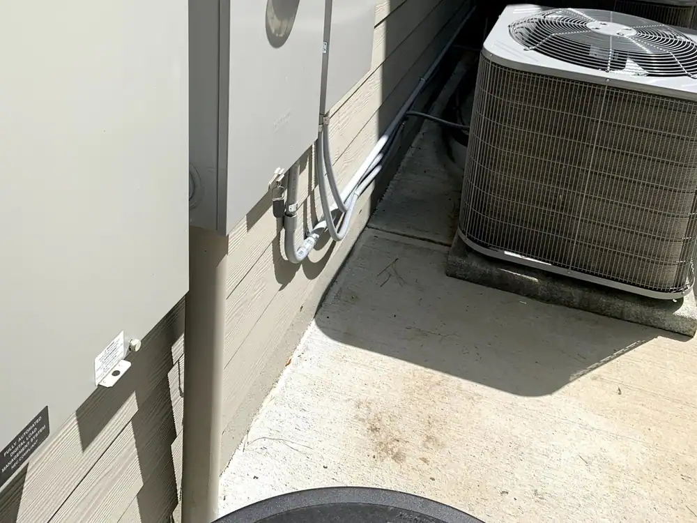 A generator and an electrical panel mounted on the exterior wall of a house, in Wakefield, Raleigh