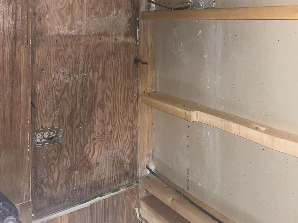 Unfinished room with exposed wooden framing, partial drywall, electrical wiring and outlet boxes mounted to the studs in Mordecai, Raleigh