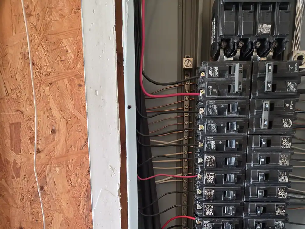 Electrical panel with a surge protector in place and wiring exposed during the installation, in Wakefield, Raleigh