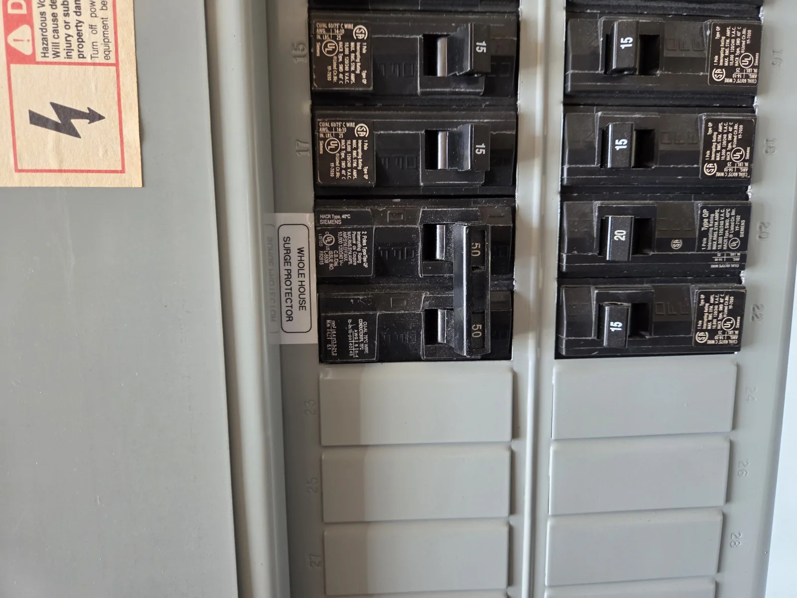Close-up of a labeled electrical panel with multiple breakers and a surge protector sticker, in Wakefield, Raleigh