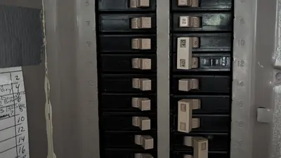 Two rows of breakers in a panel, with the numbered circuit directory beside them