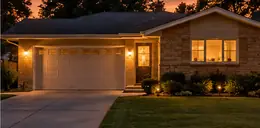1970s ranch house with a driveway at dusk