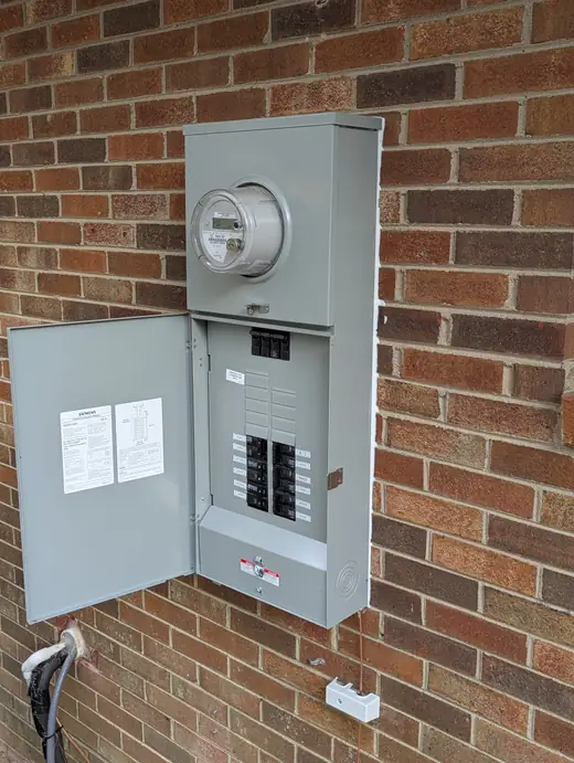 Angled view of the completed exterior 200-amp meter-main panel with its cover open in Raleigh