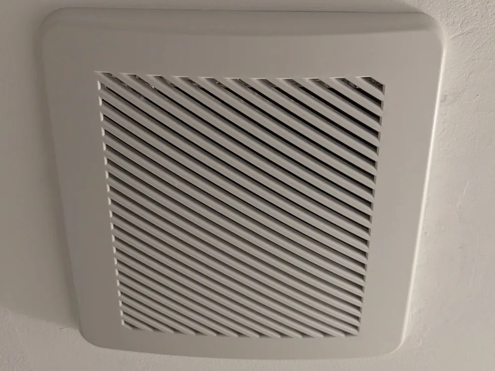 New bathroom exhaust fan grille installed flush in the ceiling
