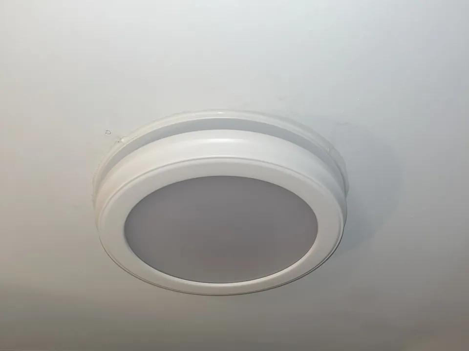 Slim round LED light installed flush in a white ceiling