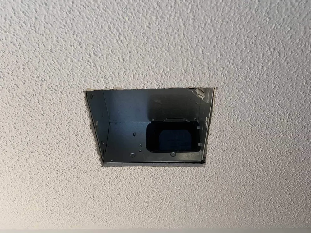 Clean new opening cut in a textured ceiling for a recessed light