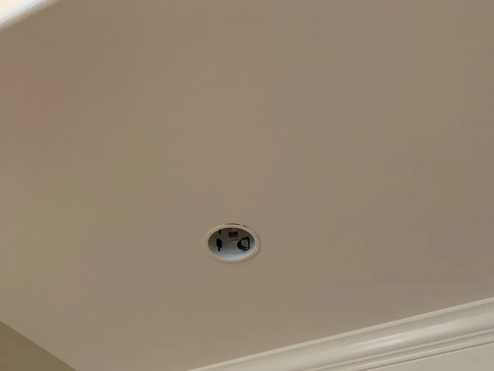 Recessed LED light set into a ceiling near the crown molding