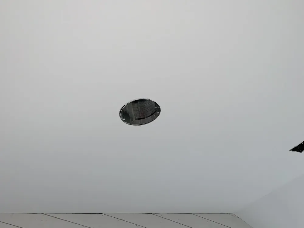 New recessed light housing installed in a finished white ceiling