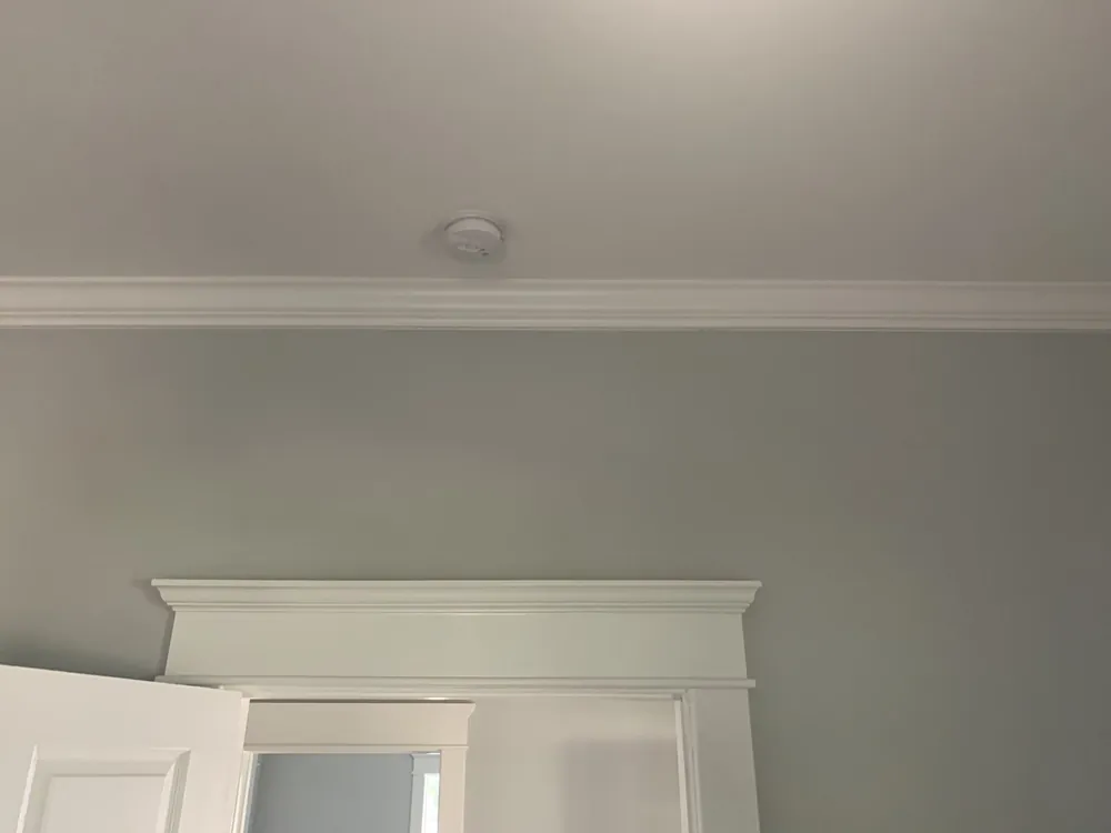 Smoke detector on a hallway ceiling outside the bedrooms