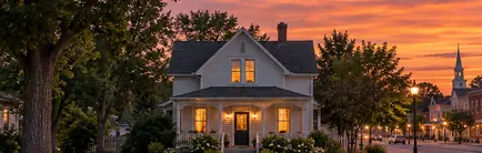 Older frame house on a quiet street near a small-town center in the evening