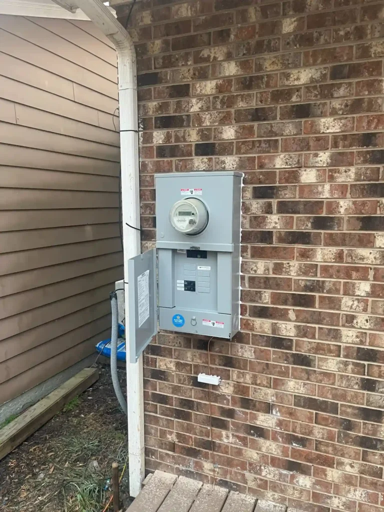Completed Exterior Electrical Panel And Meter Base Mounted On The Outside Wall Of The Home After Installation.